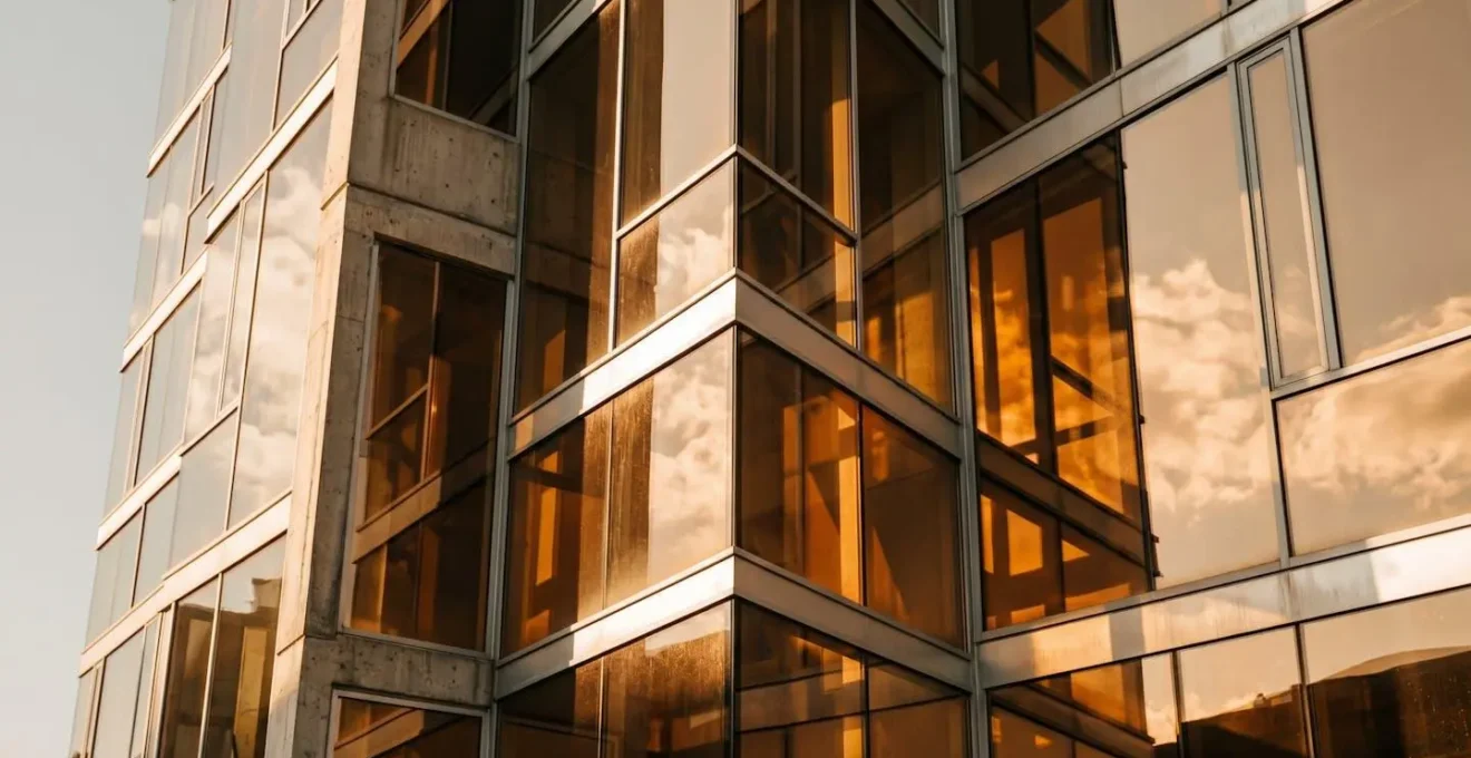 Illustration métaphorique de l'accumulation de chaleur dans un bâtiment moderne avec grandes surfaces vitrées