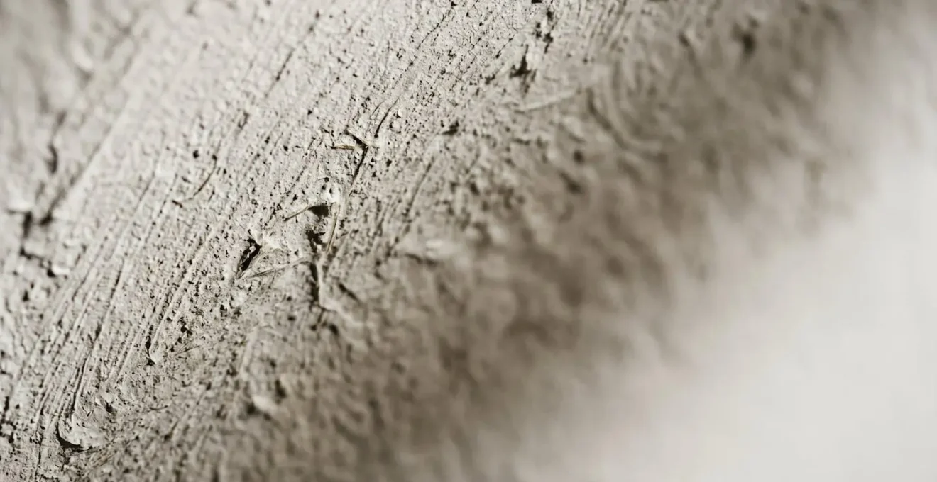 Gros plan extrême sur la texture d'une peinture naturelle appliquée sur un mur, révélant les détails et la matière